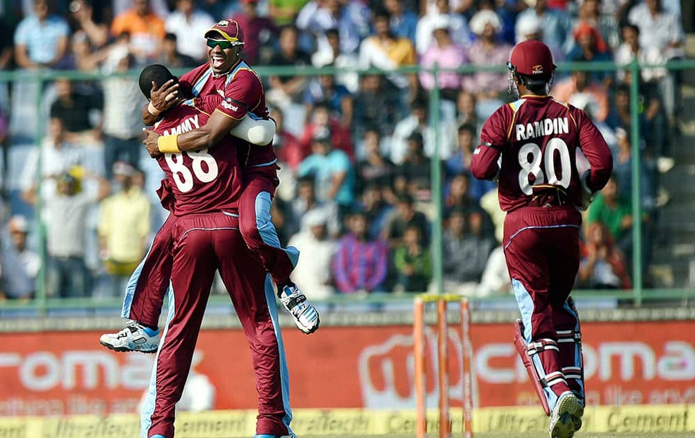 West Indies players D Bravo and D Sammy celebrate the wicket of Indias A Rahane during the 2nd ODI cricket match in New Delhi.