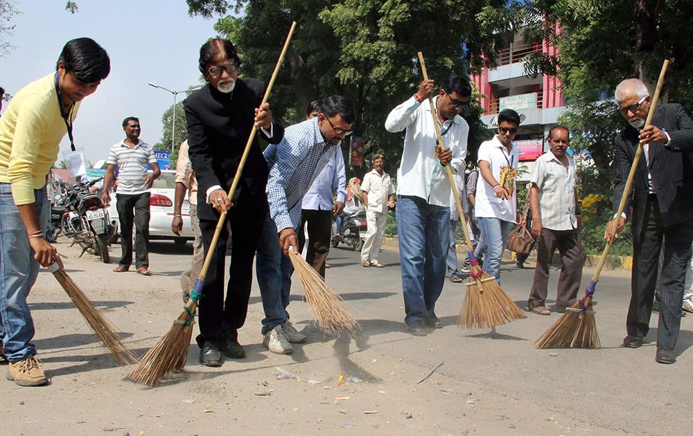 Members of Amitabh Fan Club sweep a road to celebrate the legendary actors birthday in Ahmedabad.