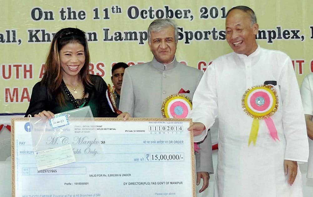 Manipur Governor KK Paul and Chief Minister O Ibobi Singh honouring gold medallist boxer Mary Kom at a felicitation ceremony for medallists and participants of the Incheon Asian Game 2014, in Imphal.