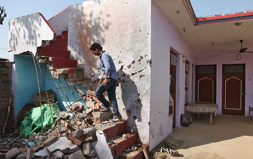 A boy walks inside his house damaged, firing between Indian and Pakistan at the border area of Treava village in Arnia sector, in Jammu.