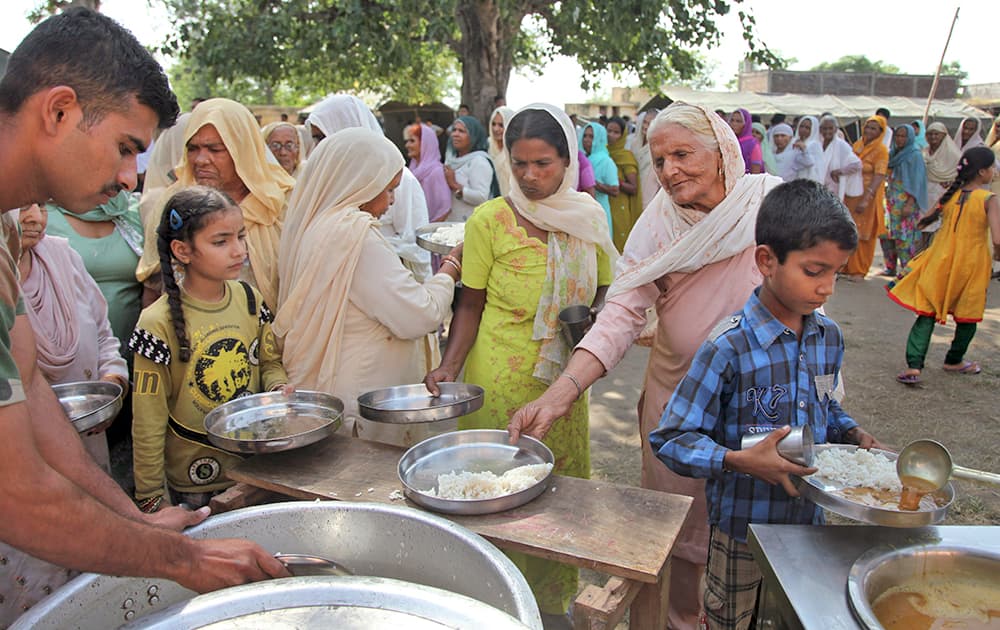 Villagers, who fled from their homes after the exchange of firing between India and Pakistan, receive food ration at an army relief camp at Deoli village, in Arnia.