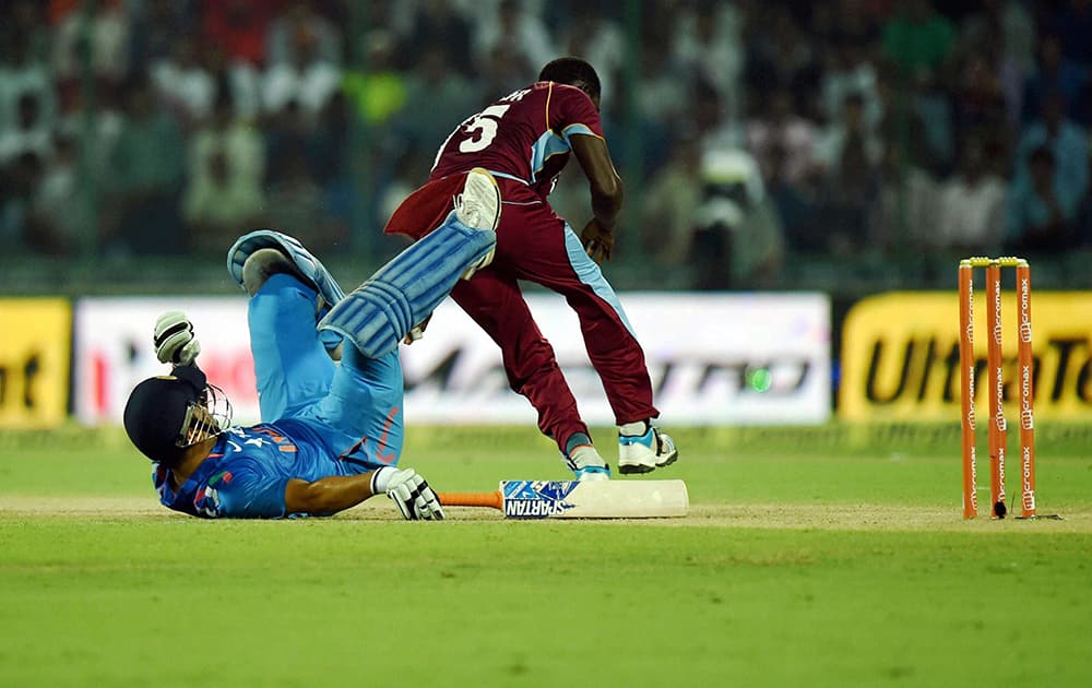 Indias skipper MS Dhoni falls on the ground during the 2nd ODI cricket match against West Indies in New Delhi.