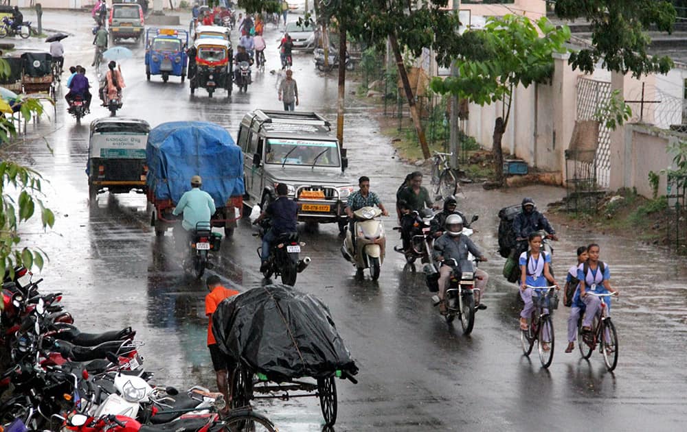 People move during rain near Gopalpur sea beach as effect of Cyclone Hudhud. The cyclone will land near Vishakhapatnam.