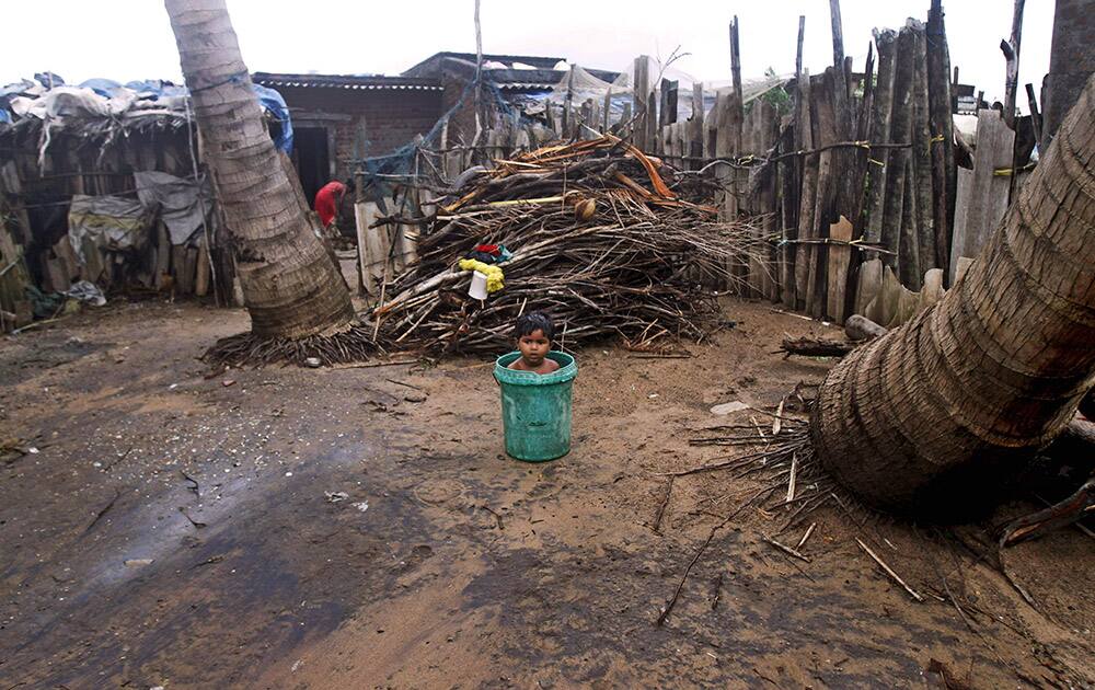 An Indian child sits inside a plastic bucket near his house on the Bay of Bengal coast at Gopalpur, Orissa, about 285 kilometers (178 miles) north east of Visakhapatnam, India.