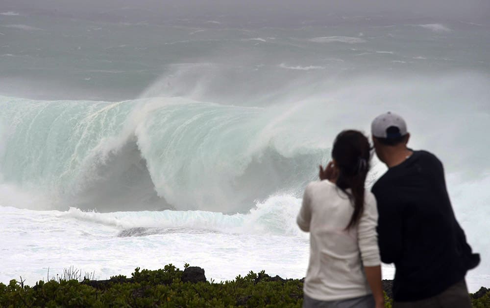 A couple watches huge wave at a cape in Yomitan Village, Japan's southern island of Okinawa.