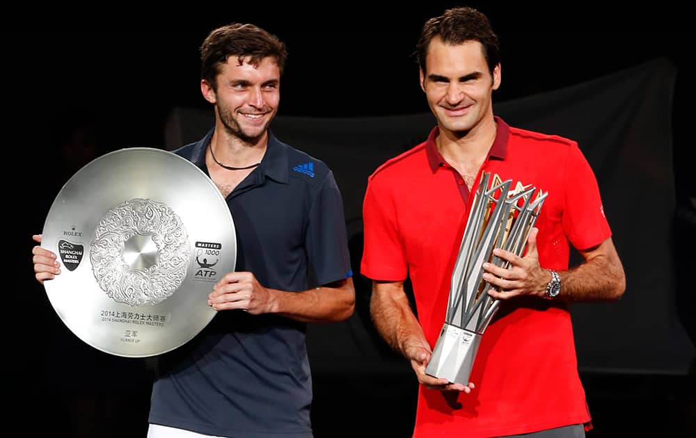 Roger Federer of Switzerland, right, and Gilles Simon of France pose with trophy during the awards ceremony after Federer won the men's singles final at the Shanghai Masters Tennis Tournament in Shanghai, China.