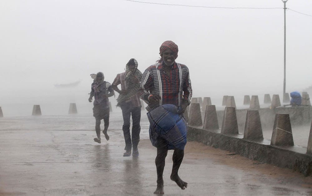 People run for shelter as heavy rain and wind gusts rip through the Bay of Bengal coast at Gopalpur, Orissa, about 285 kilometers (178 miles) north east of Visakhapatnam, India.