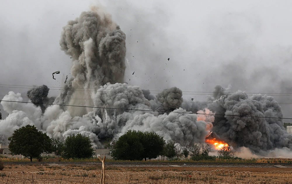 Thick smoke, debris and fire rise following an airstrike by the US-led coalition in Kobani, Syria as fighting intensified between Syrian Kurds and the militants of Islamic State group, as seen from Mursitpinar on the outskirts of Suruc, at the Turkey-Syria border.