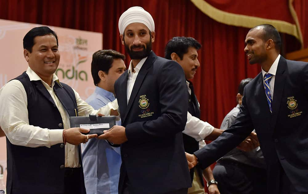 Union Minister of State (I/C) for Skill Development, Youth Affairs & Sports Sarbananda Sonowal felicitates Indian hockey team captain Sardar Singh and goalkeeper Sreejesh (R) during a felicitation ceremony for the 17th Asian Games Medalist in New Delhi.