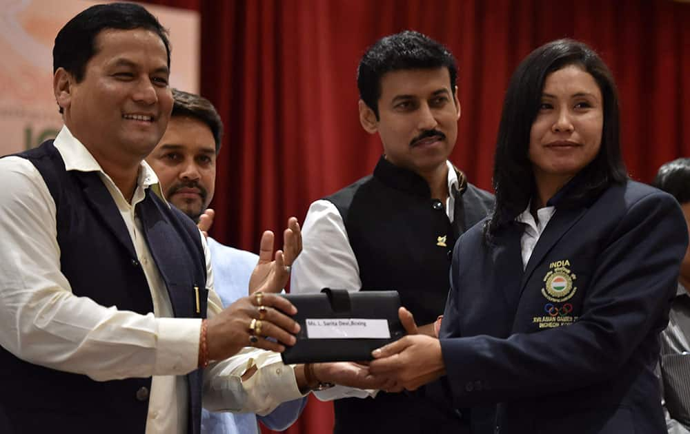 Union Minister of State (I/C) for Skill Development, Youth Affairs & Sports Sarbananda Sonowal felicitates boxer L Sarita Devi during a felicitation ceremony for the 17th Asian Games Medalist in New Delhi.