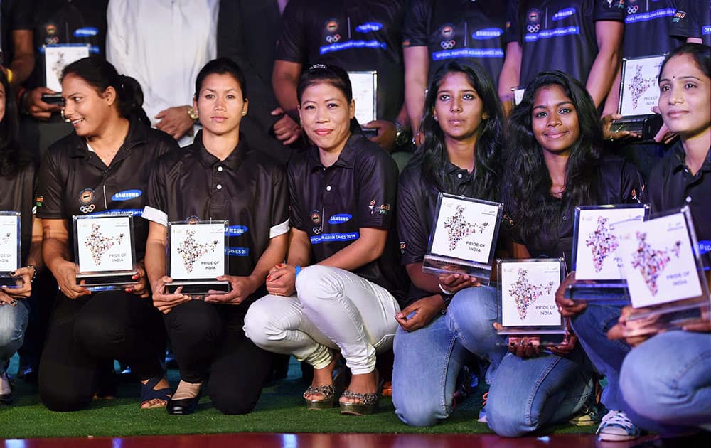 Boxer Mary Kom and other players pose for photographs during a felicitation function organised by Samsung for the medal winners of recent Asian Games, in New Delhi.