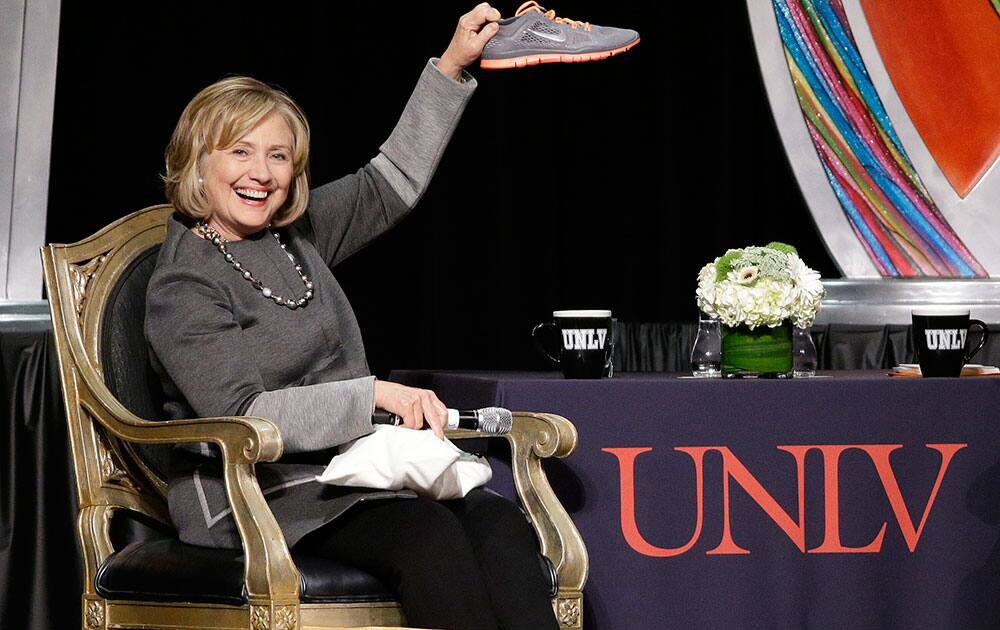 Former US Secretary of State Hillary Rodham Clinton holds up a shoe during the UNLV Foundation annual dinner in Las Vegas. The shoe was given to her by Las Vegas Sun CEO, Publisher and Editor Brian Greenspun. A woman threw a shoe at Clinton during an appearance in Las Vegas in April.