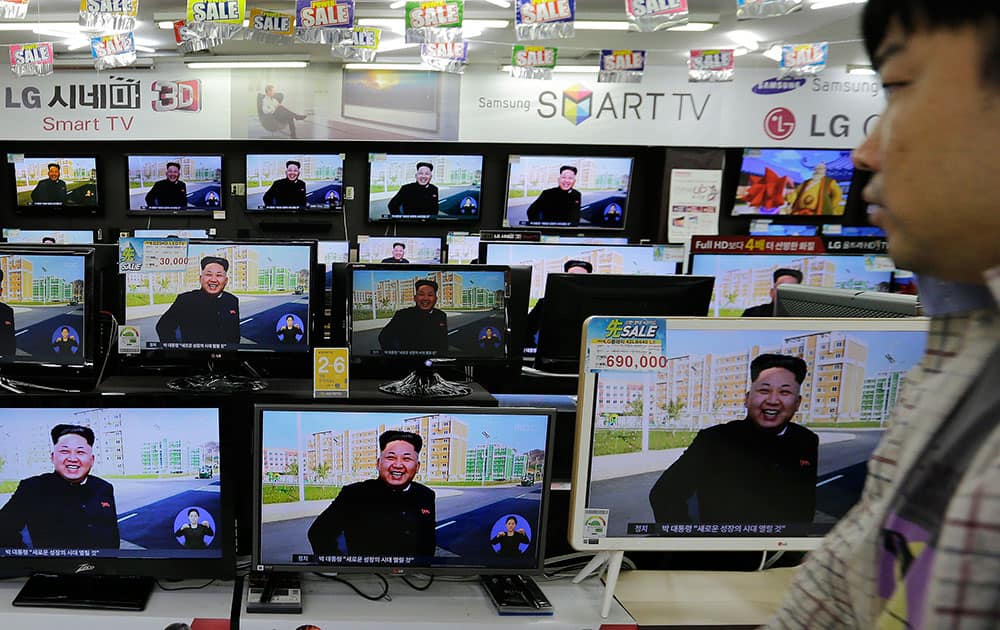 A shopper walks by TV monitors showing a news report about North Korean leader Kim Jong Un, at an electronic shop, South Korea.