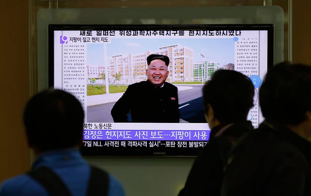 People watch a TV news program showing photographs of North Korean leader Kim Jong Un's first public appearance, at the Seoul Railway Station in Seoul, South Korea.