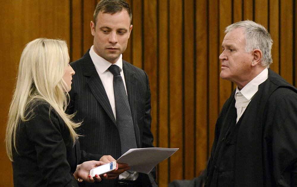 Oscar Pistorius listens to two of his legal team members at a court where the sentencing process enters its second day. Pistorius was found guilty of culpable homicide last month for the shooting death last year of his girlfriend Reeva Steenkamp.