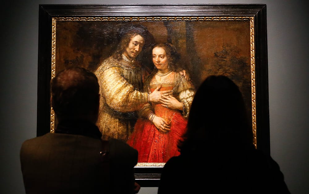 People look at Rembrandt's painting Portrait of a Couple as Isaac and Rebecca, known as 'The Jewish Bride' about 1665 during a media event at The National Gallery in London.