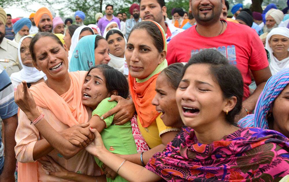 Family members of Gursahib Singh mourn during his creamation at his native village Bhakna Kalan, near Amrtisar.