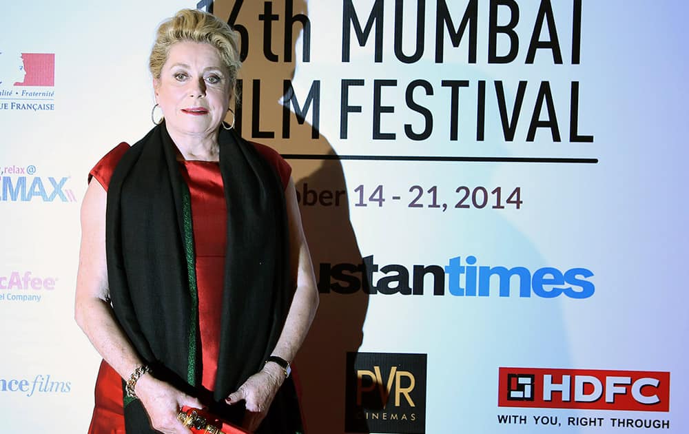 French actress Catherine Deneuve poses for photos at the opening ceremony of the16th Mumbai Film Festival in Mumbai.