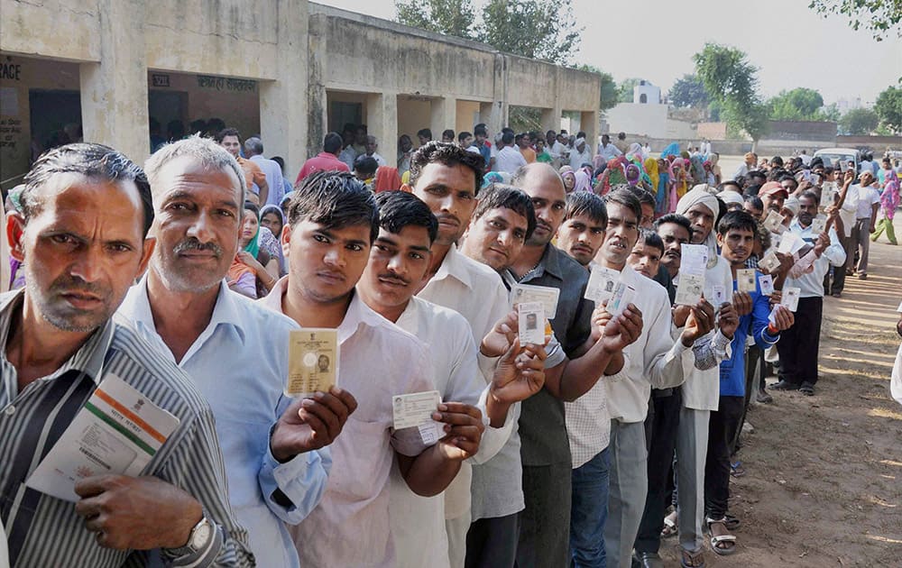 Voters wait in long queues to cast their votes for Assembly polls, at a polling station in Faridabad.