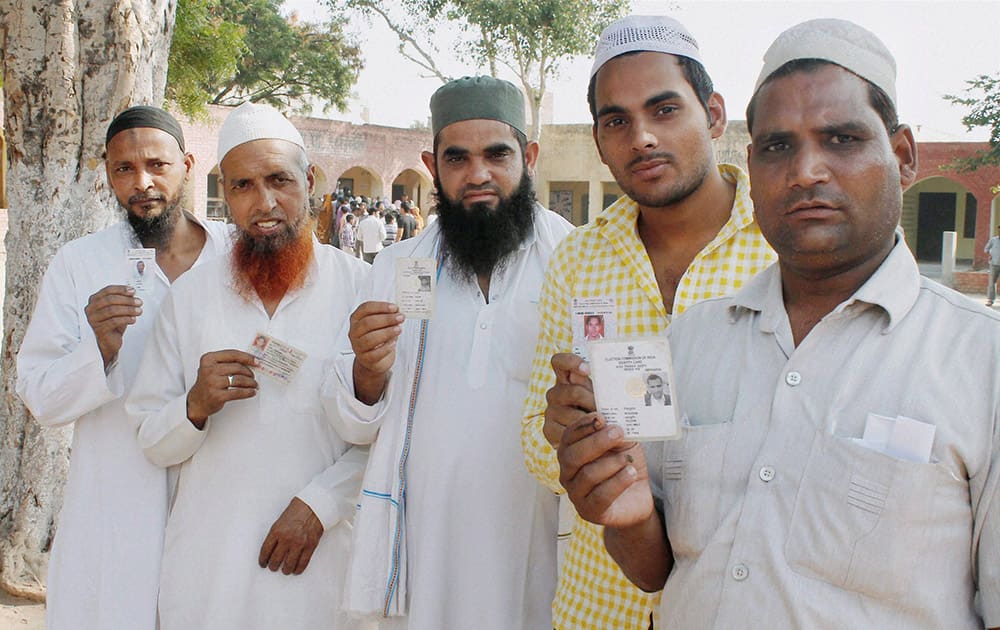 Muslim voters show their identity cards before casting votes for Assembly polls, at a polling station in Faridabad.