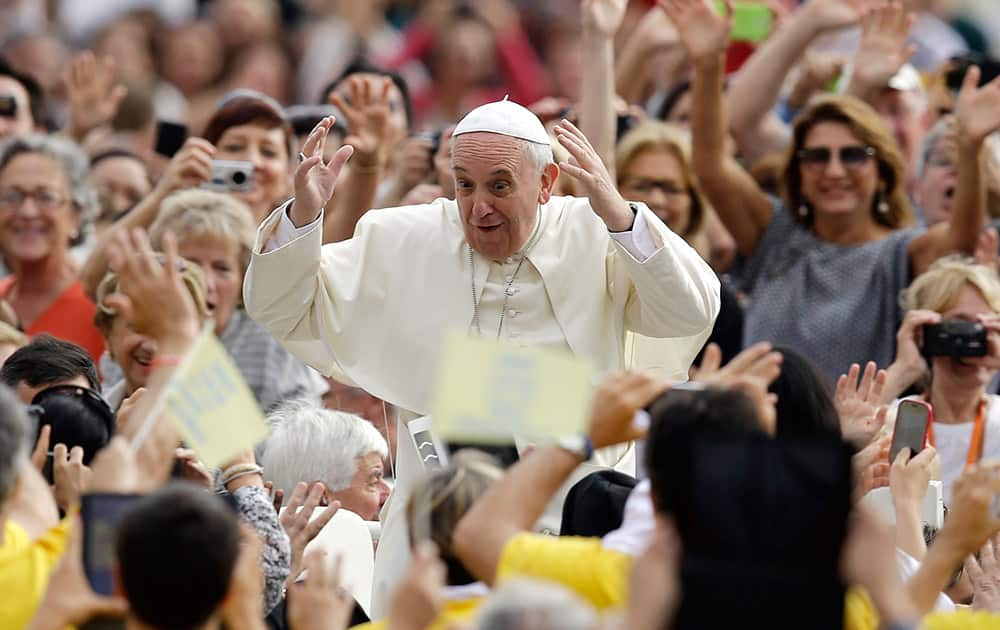 Pope Francis greets the faithful as he arrives in St. Peter's Square to attend the weekly general audience, at the Vatican.