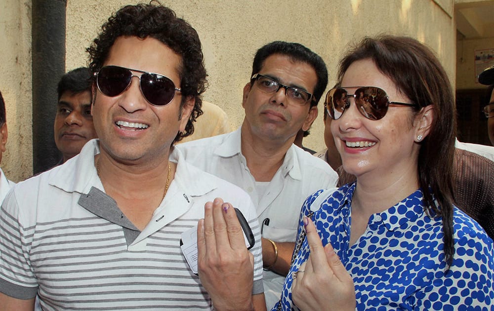 Cricket legend Sachin Tendulkar and his wife Anjali display their inked fingers after casting votes for the Assembly elections in Mumbai.