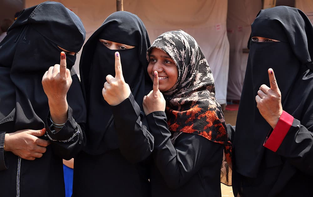 Muslim women show the ink mark on their index fingers after casting their votes to the Maharashtra state elections in Mumbai.