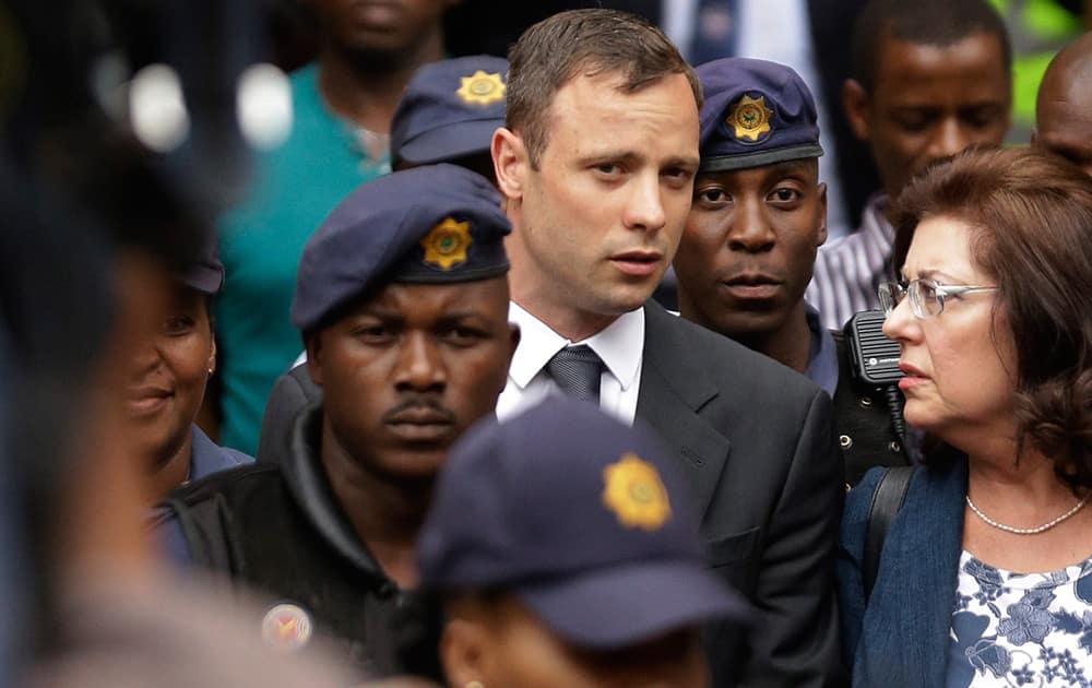 Oscar Pistorius is escorted by police officers as he leaves the high court in Pretoria, South Africa. Pistorius faces sentencing this week in a South African court after being convicted of culpable homicide for killing girlfriend Reeva Steenkamp.