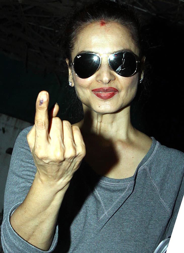 Bollywood actress and MP Rekha shows her inked finger after casting vote for the Assembly elections in Mumbai.