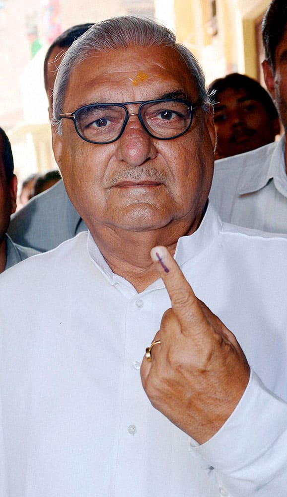 Haryana CM Bhupinder Singh Hooda shows his inked finger after casting his vote for the Assembly polls at a polling booth in Rohtak on Wednesday. 