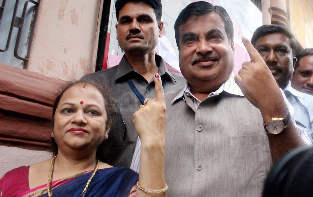  Union Minister for Transport Nitin Gadkari with his wife show their inked finger after casting their vote for the Assembly Elections at a polling station in Nagpur on Wednesday. 