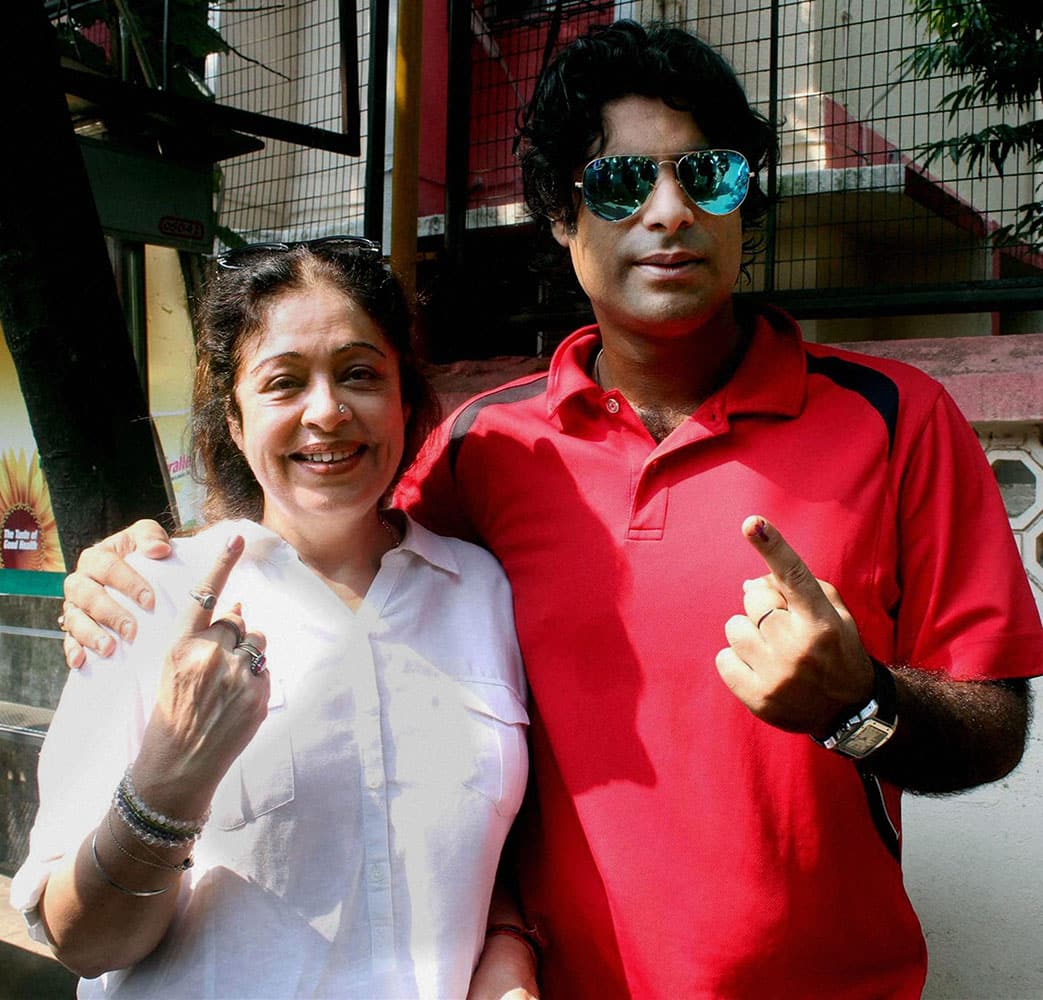 Actress and BJP MP Kirron Kher with her son showing inked finger after casting her vote for the Assembly elections at a polling station in Mumbai on Wednesday. 