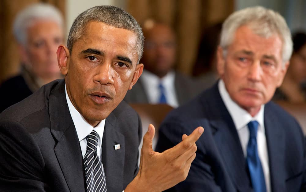 President Barack Obama, next to Secretary of Defense Chuck Hagel, speaks to the media about Ebola during a meeting in the Cabinet Room of the White House in Washington.