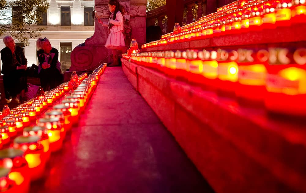 A girl walks with a lit candle during an event marking the international Pregnancy and Infant Loss Remembrance Day in Bucharest, Romania.