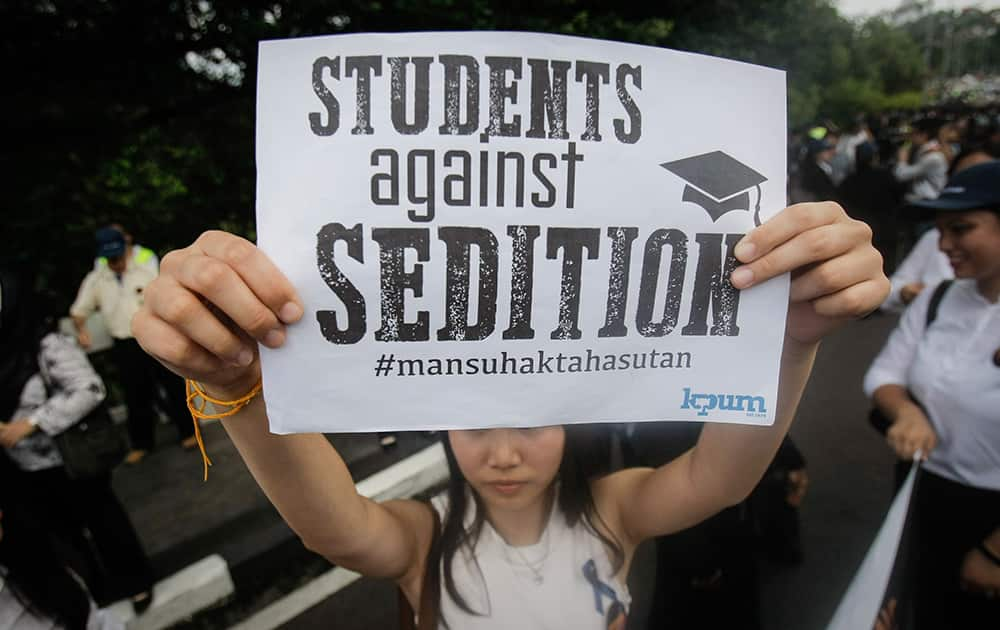 A protestor holds a placard during a protest rally in front the House of Parliament in Kuala Lumpur, Malaysia.