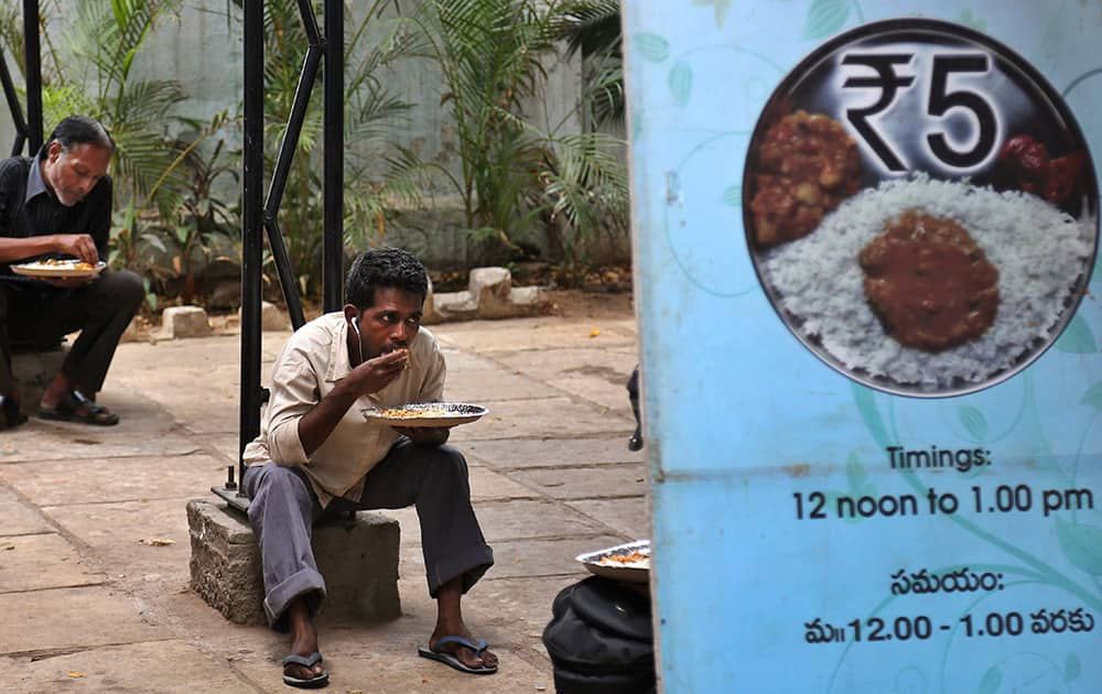 Men eat a midday meal provided by the Greater Hyderabad Municipal Corporation (GHMC) at the cost of five Indian rupees (8 cents) on World Food Day in Hyderabad.