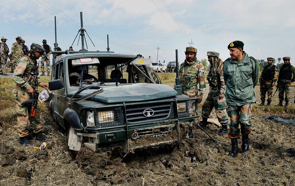 Army personnel inspecting their vehicle which was damaged during a blast by militants in Baramulla.