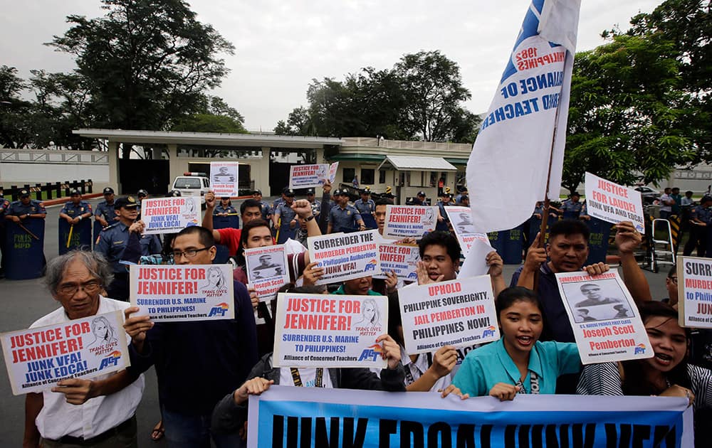 Protesters shout slogans while displaying their messages at a rally at the US Embassy in Manila to reiterate their demand to take custody of a US Marine who is a suspect in the killing of Filipino transgender, in the Philippines.