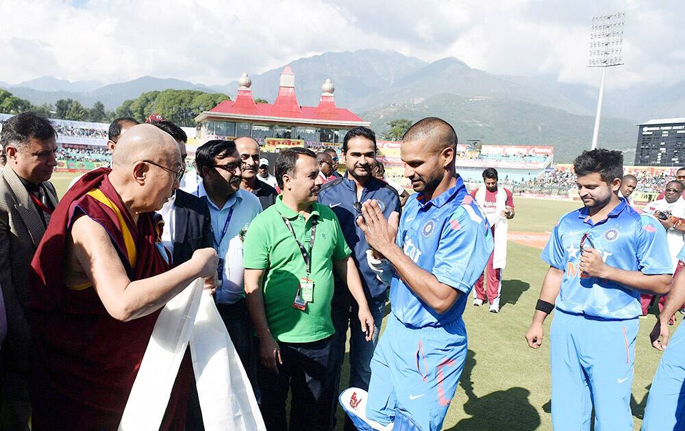 Cricketers Shikhar Dhawan and Suresh Raina shakes hand with spiritual leader Dalai Lama before the start of 4th ODI match between India and West Indies.