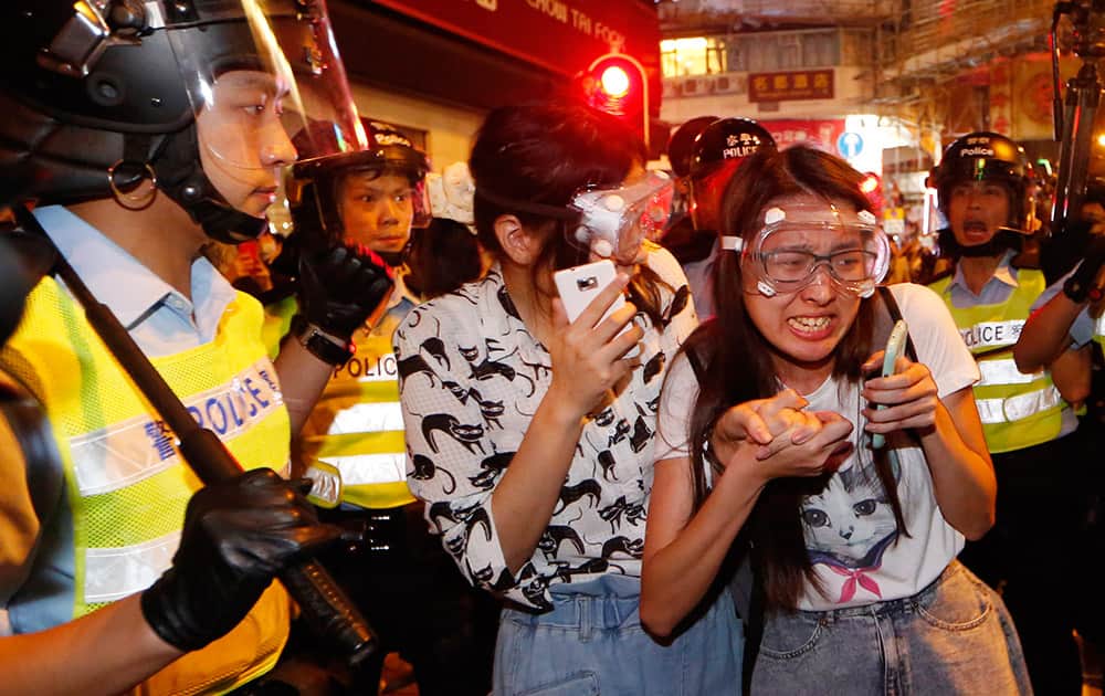 Protesters cry as some of the protesters are beaten by riot police in the occupied area in the Mong Kok district of Hong Kong.