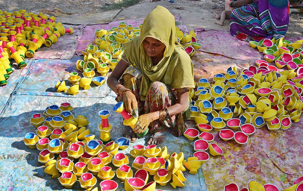 A woman paints earthen lamps ahead of Diwali festival in Amritsar. People buy these lamps to decorate their homes during the annual Hindu festival of lights, which will be celebrated on October 23. 