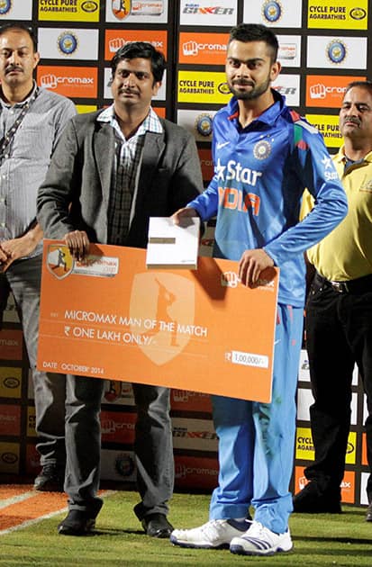 Virat Kohli receives man of the match award for the India-West Indies ODI match in Dharamshala.