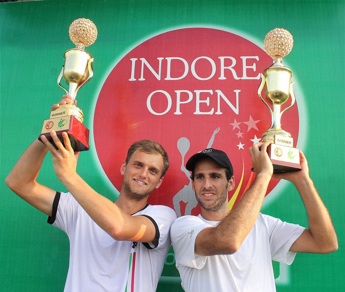 Aleksandr Nedovyesov of Kazakhstan with Adrian Menendez-Maceiras of Spain showing their trophies after winning the final match against Indias Yuki Bhambri and Divij Sharan at Indore Open ATP challenger tennis tournament, in Indore.