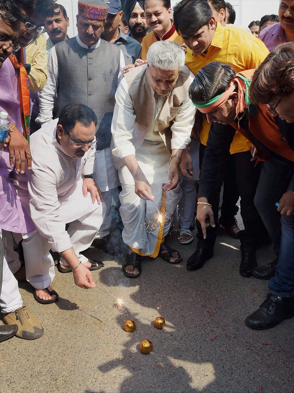 BJP general secretaries J P Nadda and Ram Lalji with party supporters burst crackers while celebrating the partys victory in Haryana and Maharashtra Assembly elections, in New Delhi.