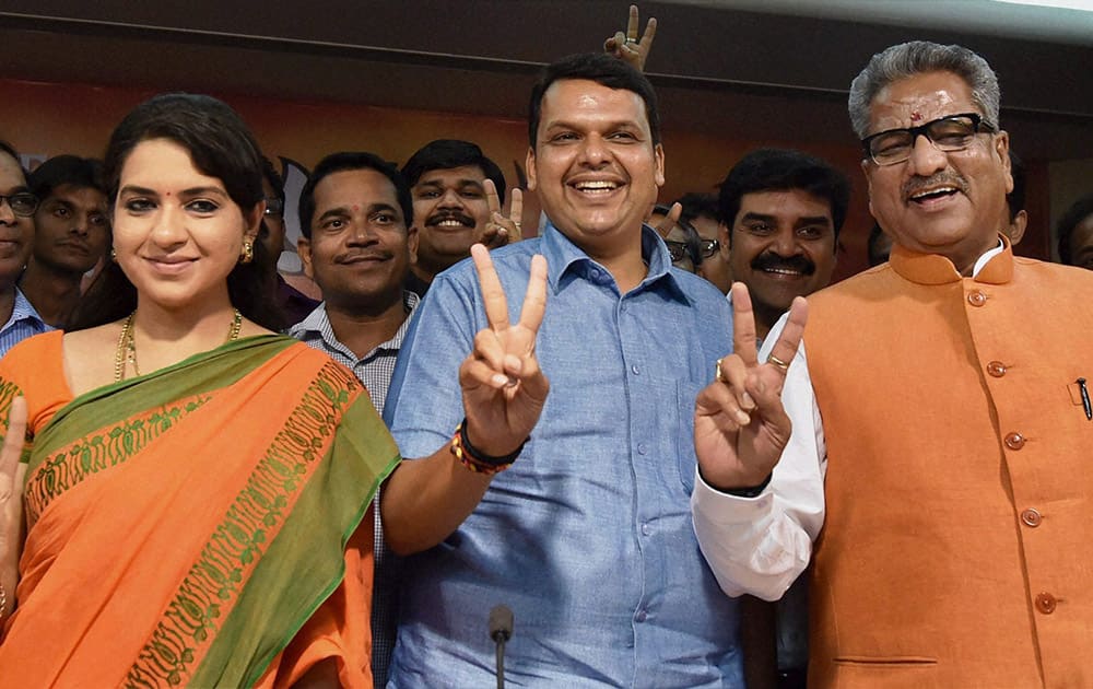 BJP leaders Shaina NC, Devendra Fadnavis and Om Prakash Mathur flash victory sign as they celebrate the partys win in assembly elections.