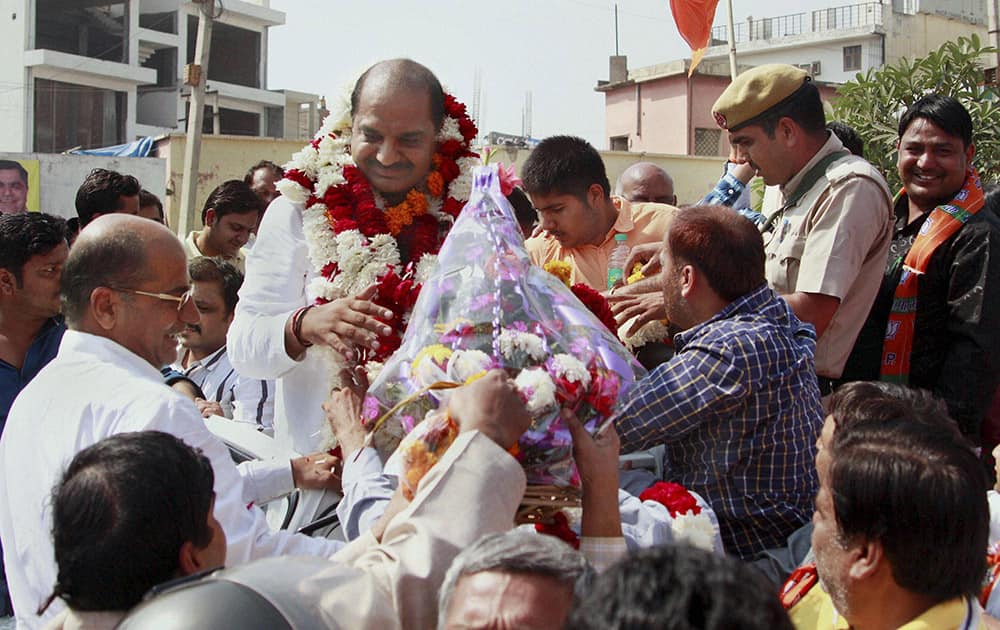 BJP candidate Umesh Aggarwal receives a bouquet after his win in the Assembly elections in Gurgaon.