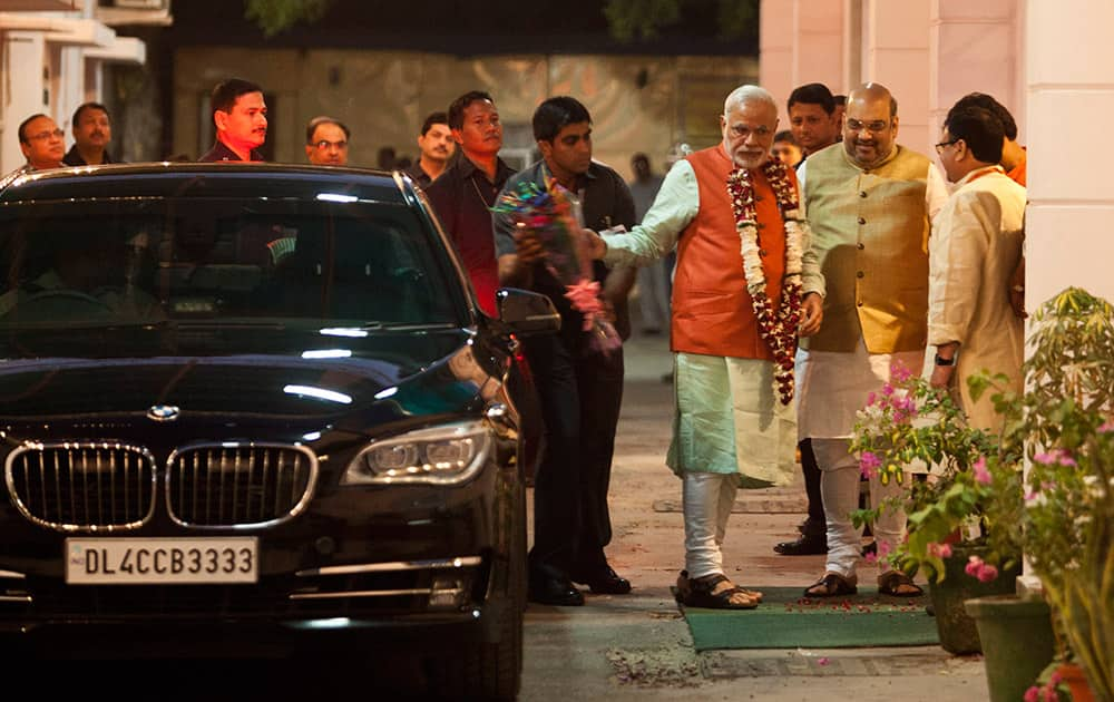 Prime Minister Narendra Modi, wearing a floral garland presented to him by Bharatiya Janata Party (BJP) party president Amit Shah, arrives for a meeting at the BJP office in New Delhi.