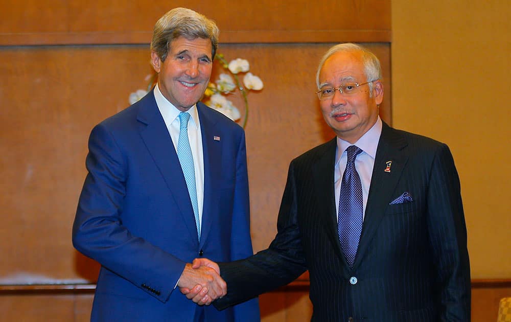 US Secretary of State John Kerry, left, and Malaysia's Prime Minister Najib Razak shake hands at the beginning of a meeting in Jakarta.