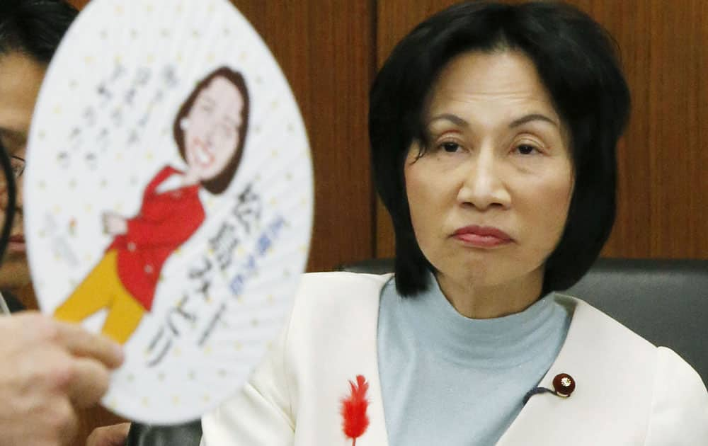 Japan's Justice Minister Midori Matsushima listens to a question by a lawmaker about a hand-held fan, or `uchiwa,` which is said to be distributed by Matsushima with her illustration and her policy on the other side during a summer festival in her constituency in Tokyo before becoming the minister, during a meeting of the Committee on Judicial Affairs in the lower house of the Parliament in Tokyo. 