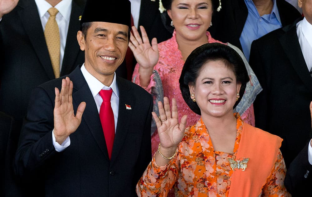 Indonesia's seventh President Joko Widodo, left, waves with his wife Iriana during a group photo following his inauguration at Parliament in Jakarta, Indonesia.